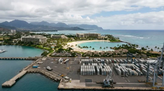 Vue aérienne contrastée montrant le paysage industrialo-portuaire du Port face à la côte balnéaire de Saint-Gilles à La Réunion