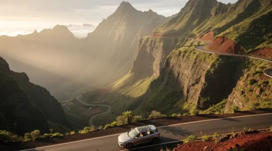 Véhicule traversant une route sinueuse dans les cirques montagneux de La Réunion avec plusieurs passagers