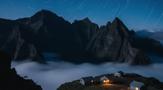 Vue nocturne du cirque de Mafate à La Réunion avec ciel étoilé et gîtes éclairés dans la montagne