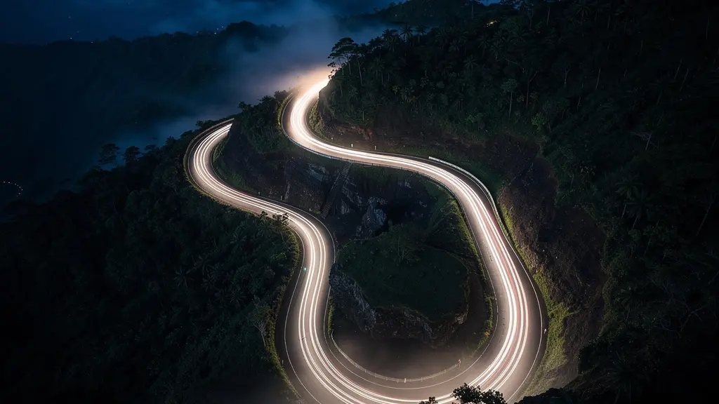 Route sinueuse de montagne à La Réunion de nuit avec phares de véhicule