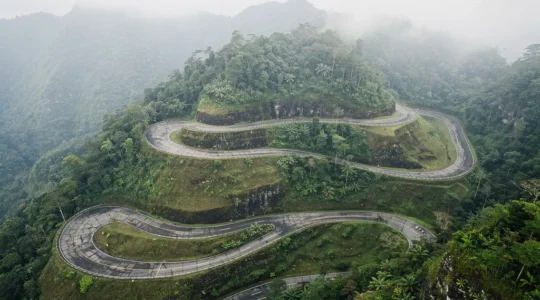 Route de montagne sinueuse à La Réunion avec virages en épingle et végétation tropicale