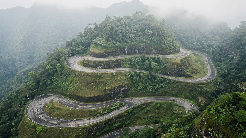 Route de montagne sinueuse à La Réunion avec virages en épingle et végétation tropicale