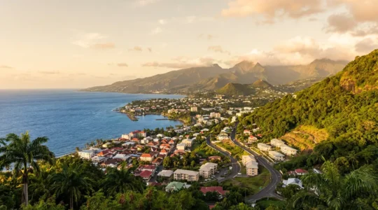 Vue panoramique d'une ville côtière de La Réunion avec montagnes volcaniques en arrière-plan